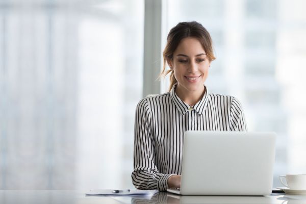 Woman in a stripped shirt looking at a laptop