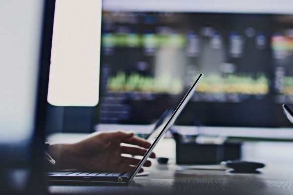 close up of people on laptops with a screen in the background